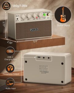 Flatsons FBA-10 white wireless portable amplifier on a wooden desk with coffee mug, smartphone, and electric guitar neck