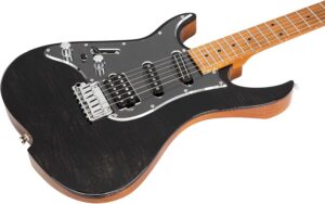 Left-handed electric guitar resting beside a home studio setup