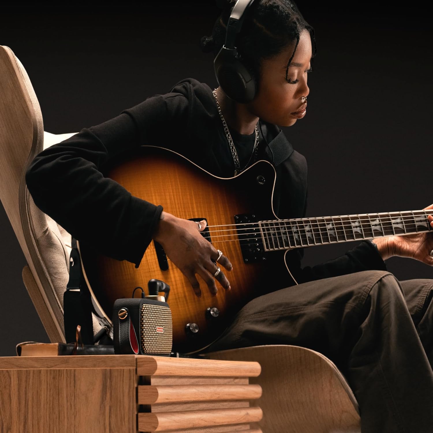 Positive Grid Spark GO ultra-portable smart guitar amp on a desk with a guitar cable connected