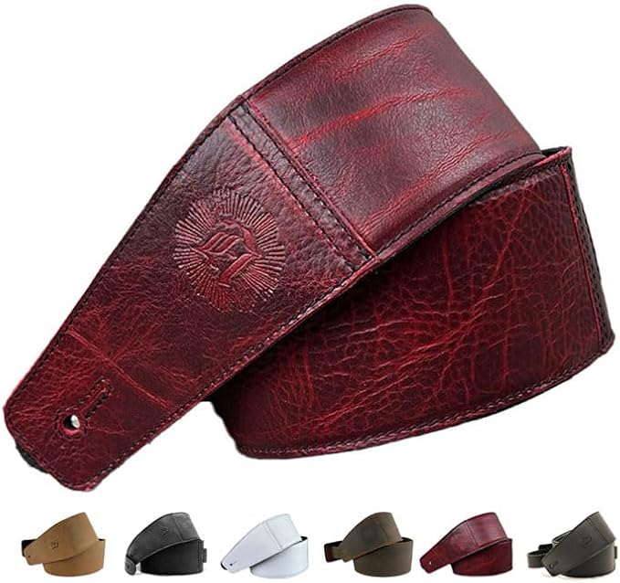 Deep red full grain leather guitar strap attached to an electric guitar in a studio setting.